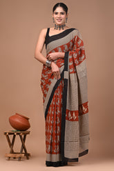 Woman wearing a traditional mul cotton saree with a brown background