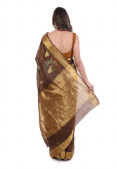 Woman wearing a brown and gold saree with floral patterns on a white background
