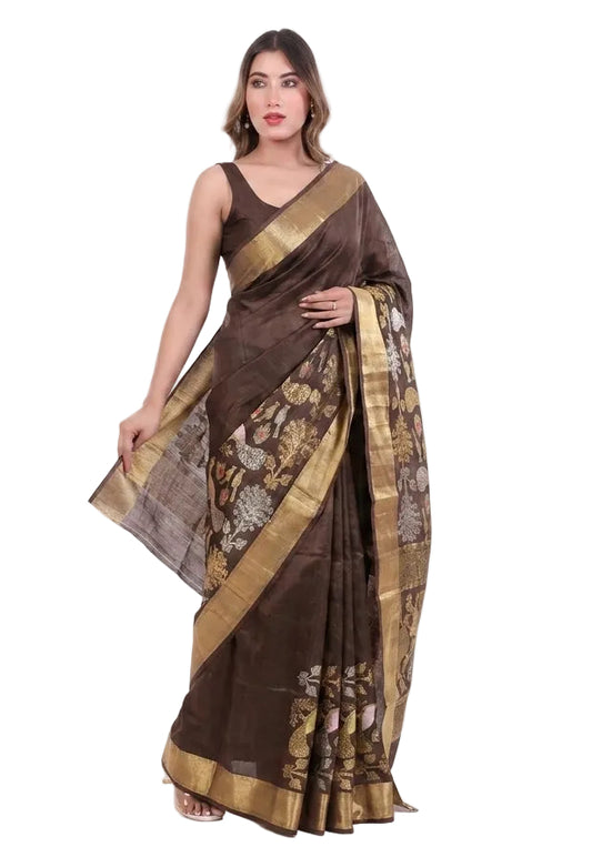 Woman wearing a brown saree with gold patterns on a white background