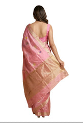 Woman wearing a pink saree with a gold border on a beige background