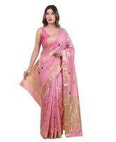 Woman wearing a pink saree with a gold border on a beige background