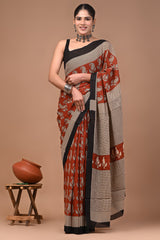 Woman wearing a traditional mul cotton saree with a brown background