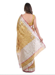 Woman wearing a gold and white saree on a white background