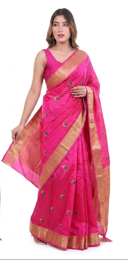 wearing pink sarees with gold borders on a white background