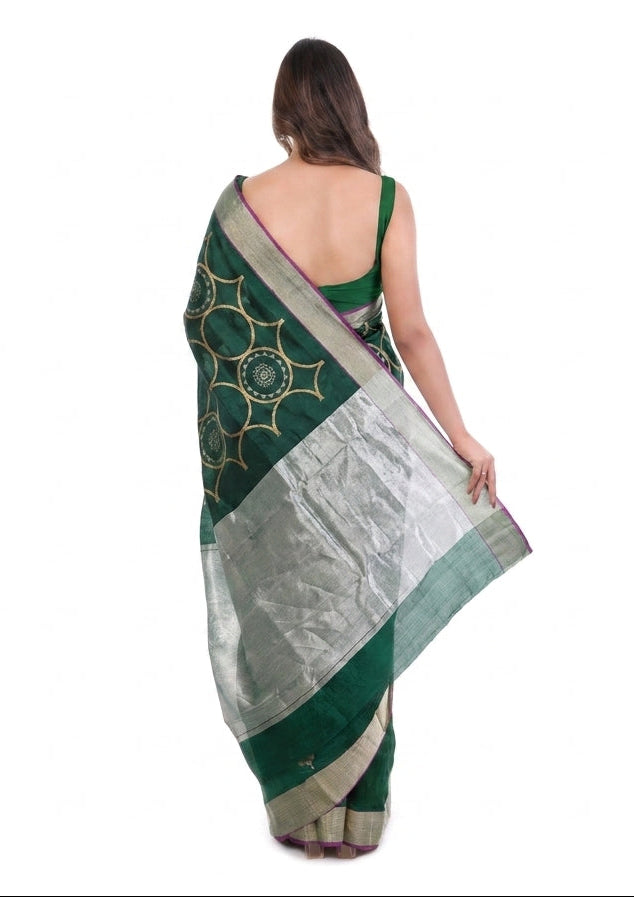 Woman wearing a green and white saree with a white background