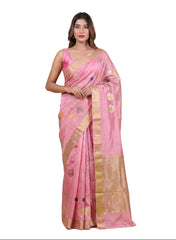 Woman wearing a pink saree with a gold border on a beige background